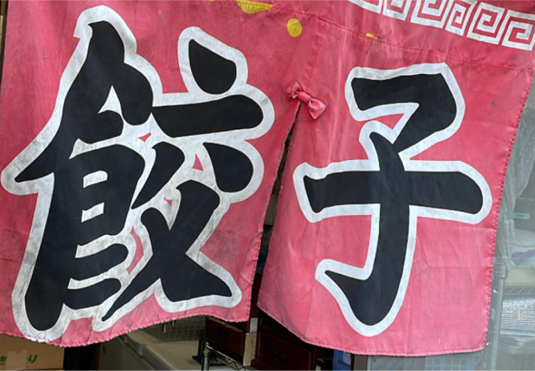 店舗の前で店主が立っている